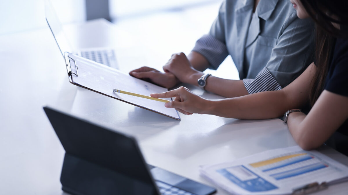 Cropped shot of businesswomen sitting at office desk talking of business plan and strategy.