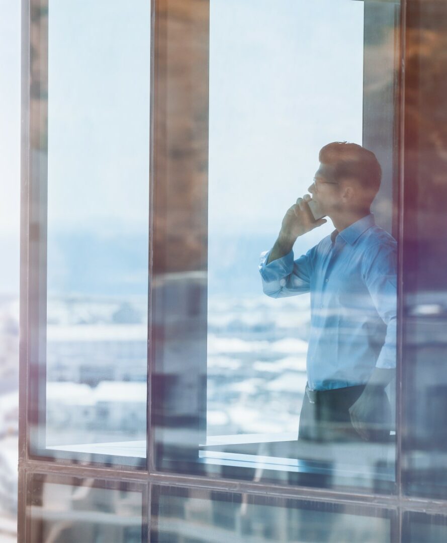 Businessman inside office building talking on mobile phone